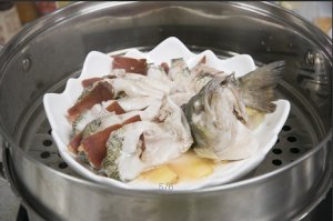 將鱸魚成花狀擺好，將火腿切片放入各縫隙中，放入鍋中隔水蒸12分鐘拿出，撒上蔥花即可。