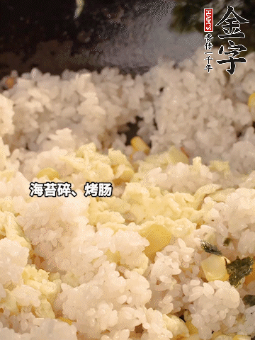 剩米飯下鍋炒散，依次下玉米粒、雞蛋、烤腸、海苔碎翻炒均勻。