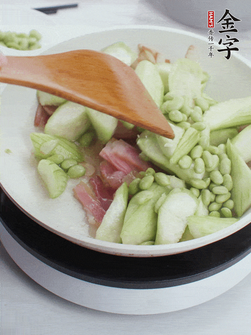 依次下絲瓜、青豆翻炒，炒至絲瓜打蔫縮小。