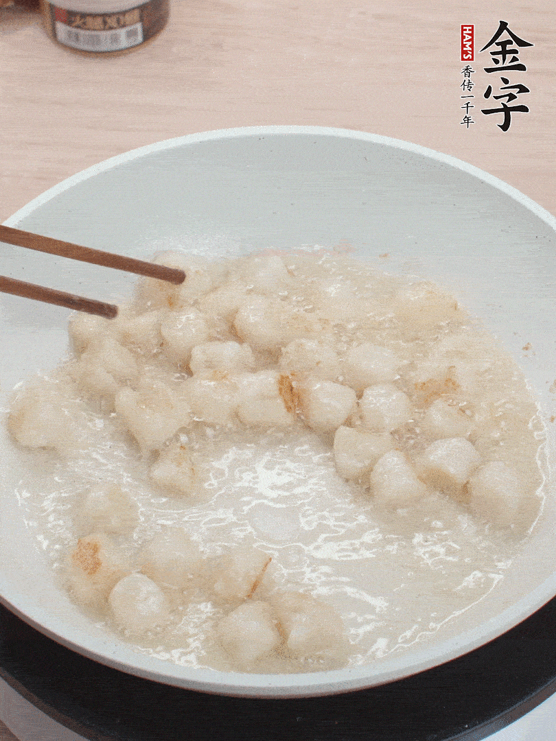 油溫4成熱，鮮貝蘸干淀粉下鍋煎，一面微黃后翻面。