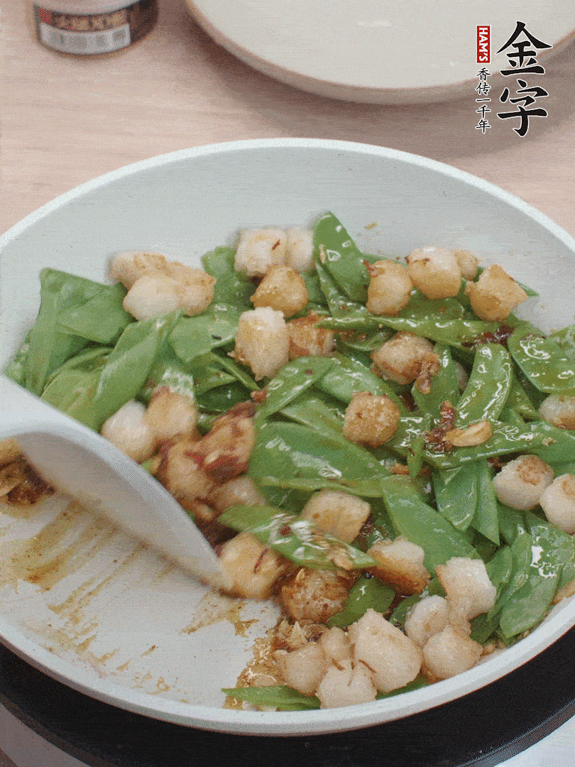 下甜豆莢、鮮貝輕輕翻炒均勻。