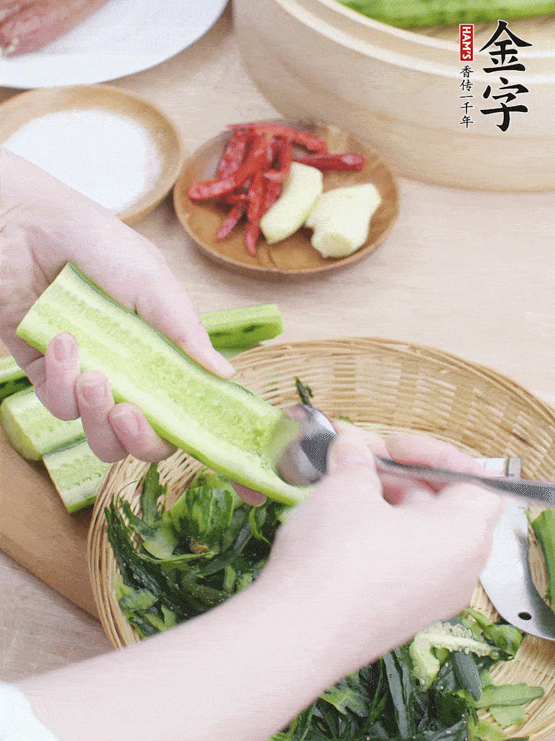 黃瓜削皮，對(duì)半切開，勺子挖去內(nèi)瓤，斜刀切片。青蒜斜刀切段。