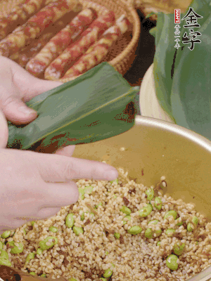 粽葉往下折，完全蓋住，兩側(cè)捏緊。