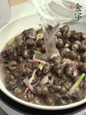 倒處理干凈的螺螄翻炒，加3勺料酒。加清水蓋過螺螄，中火蓋蓋煮5分鐘。
