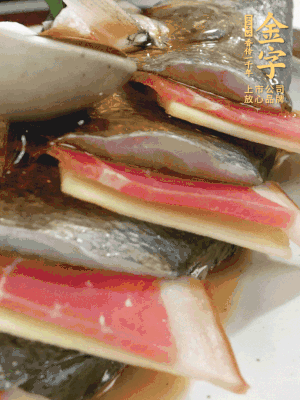 魚肚中塞蔥結(jié)、火腿片，魚身上碼放姜片、火腿片，倒入混合的料汁。