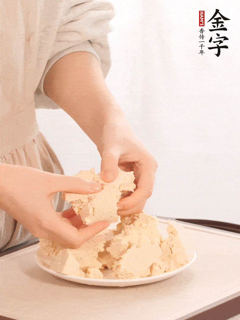 老豆腐用手掰成塊。