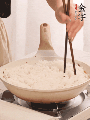 把瀝干水分的米飯均勻鋪在上面，筷子戳幾個(gè)洞，以便透氣，轉(zhuǎn)小火蓋上蓋子燜至水分收干，大概10分鐘。